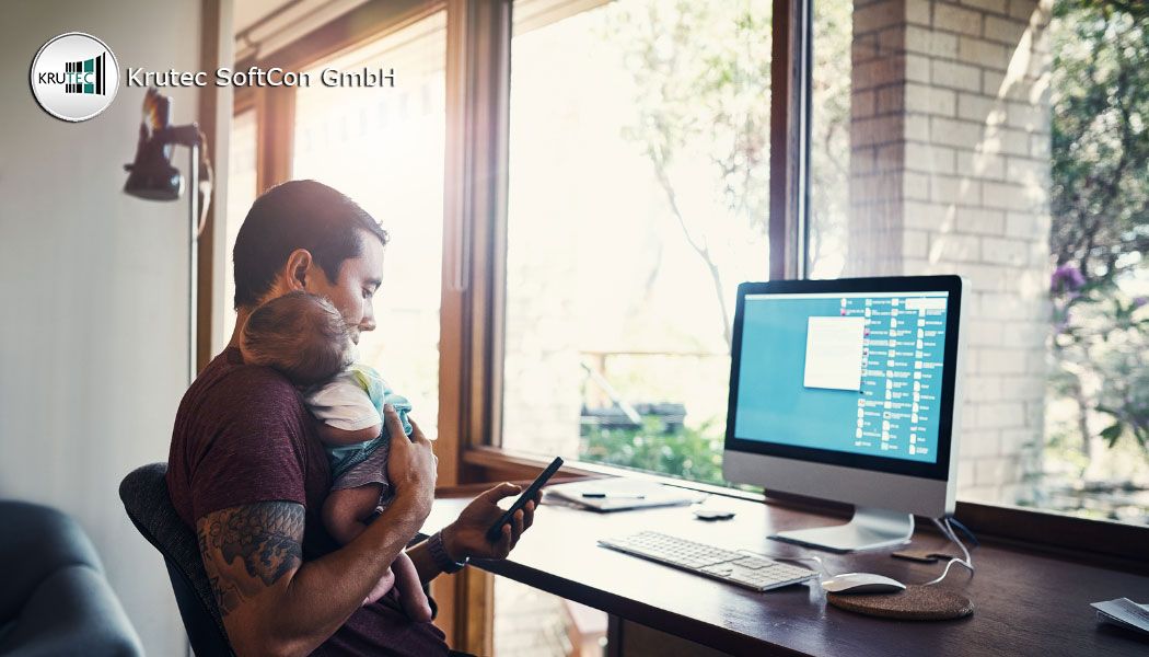 Mann in Brückenteilzeit arbeitet am Rechner und hält ein Baby auf dem Arm
